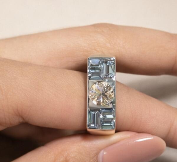 Wide band ring with aquamarine baguettes and round center diamond